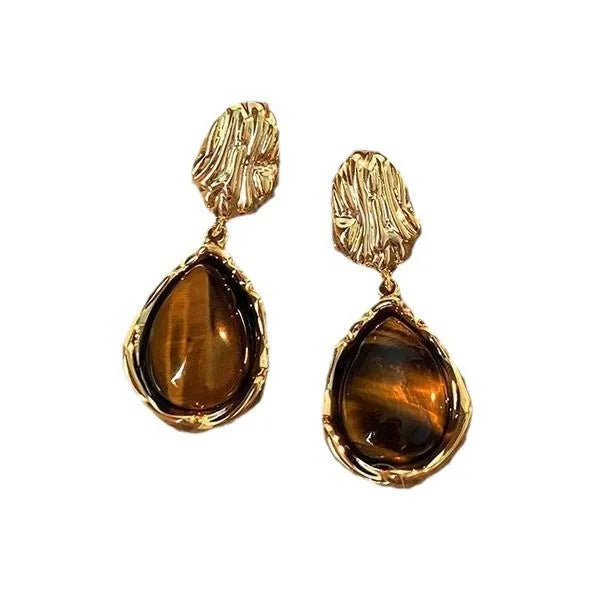 Set of three pairs of geometric holiday earrings: round studs, irregular amber studs, and tassel drop earrings.