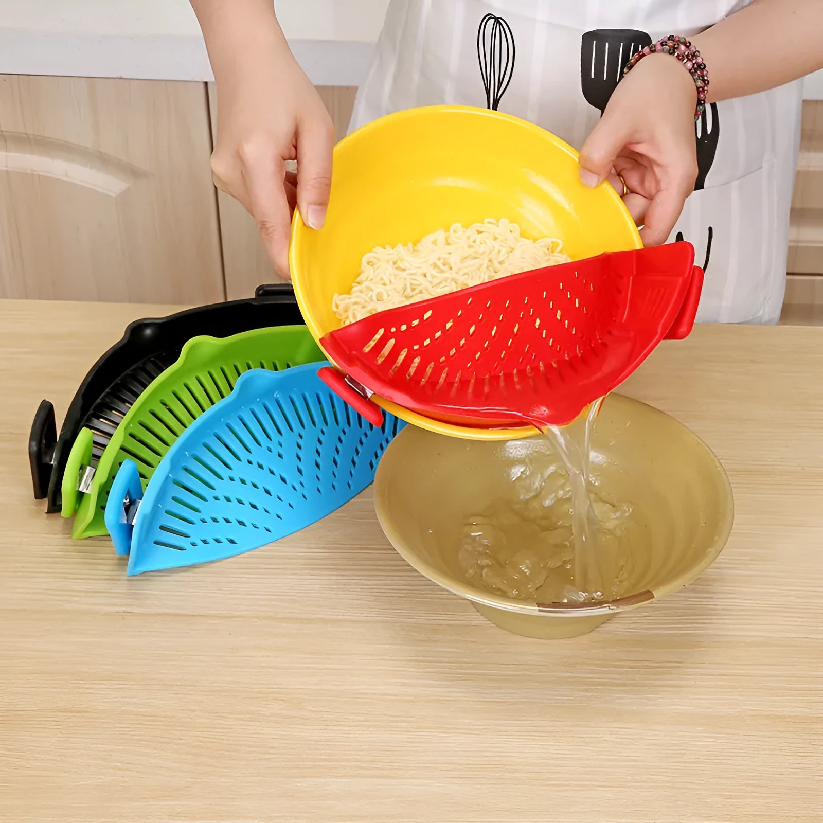 Silicone clip-on funnel strainer attached to a pot rim for draining liquids.