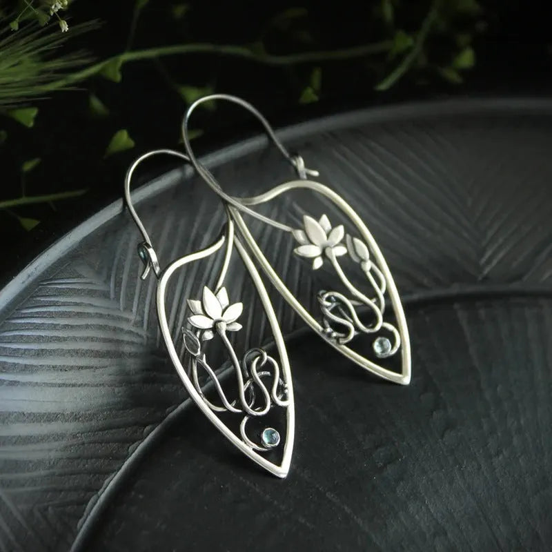 Silver geometric lotus vine earrings with rhinestone accents on white background