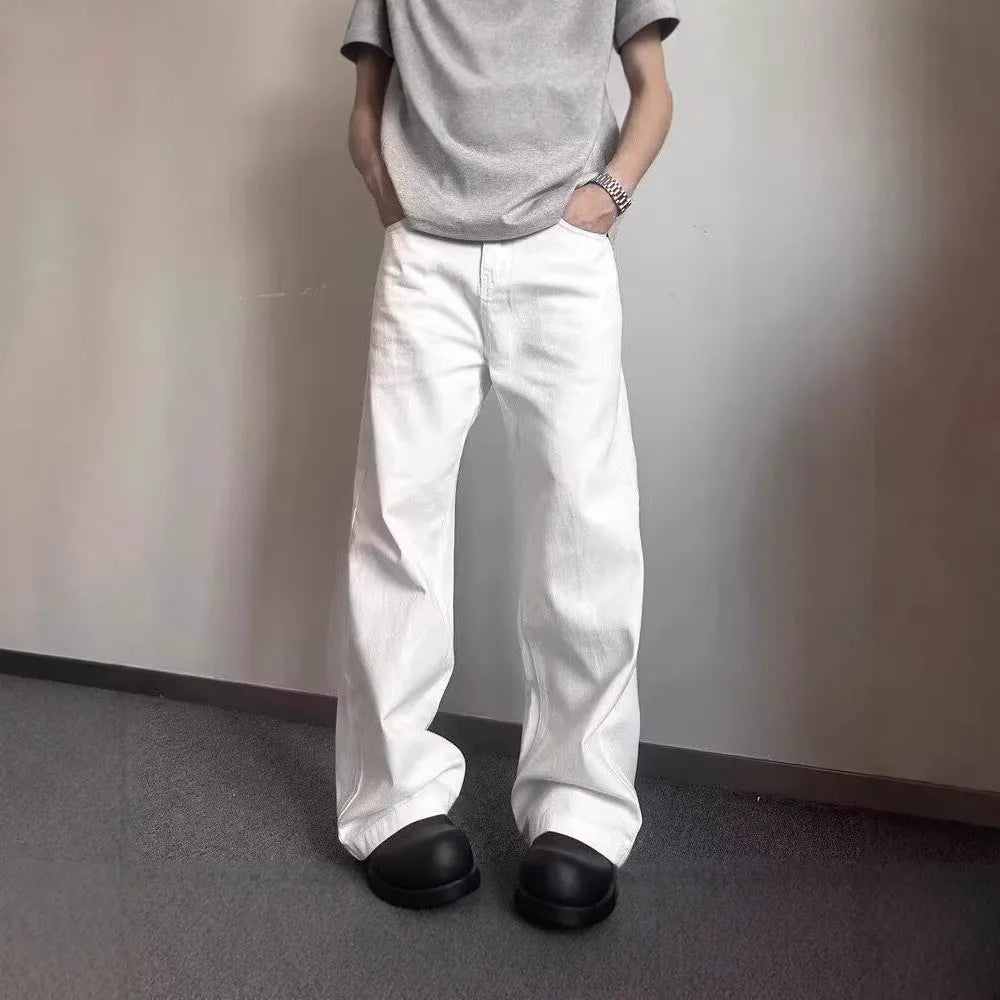 Man wearing white straight-leg cotton denim jeans with a wide leg opening.