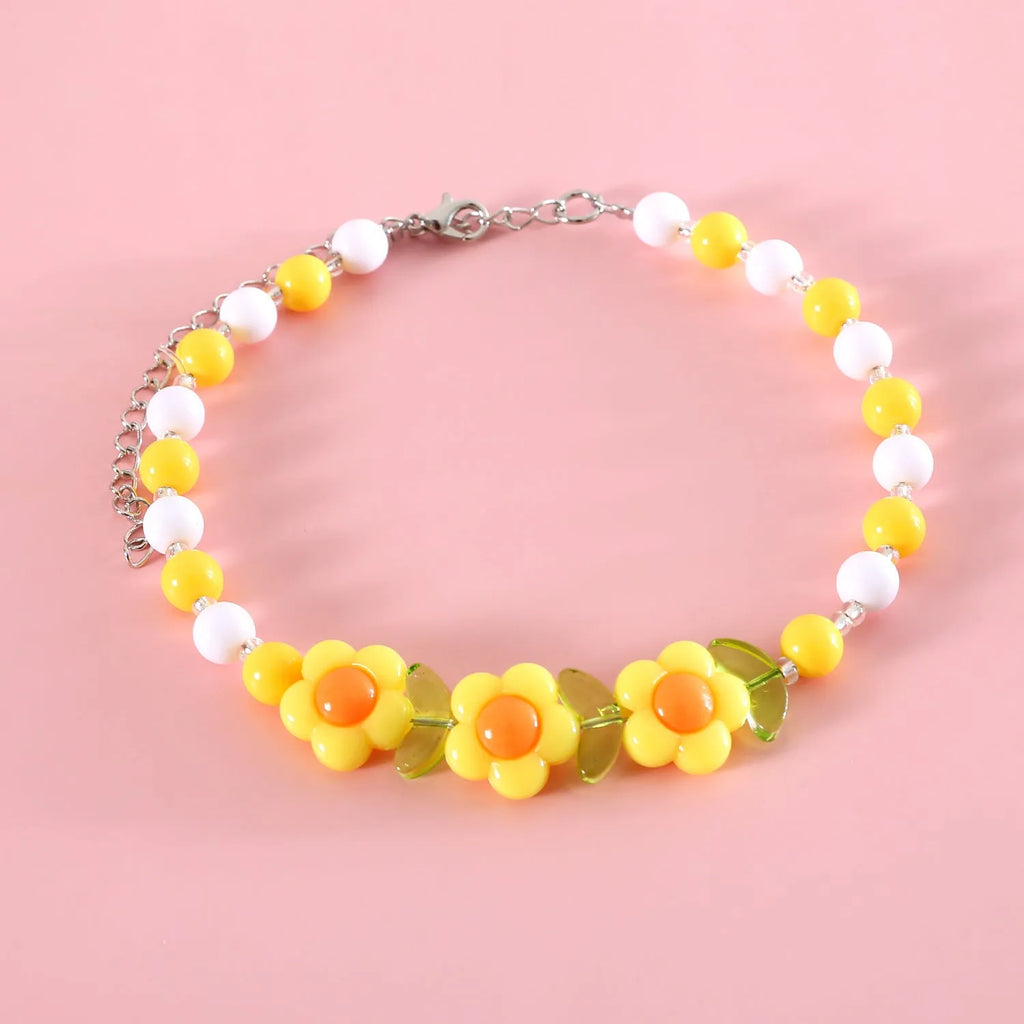Colourful plastic bead pet necklace in small flower, rainbow, or peach design on an adjustable collar
