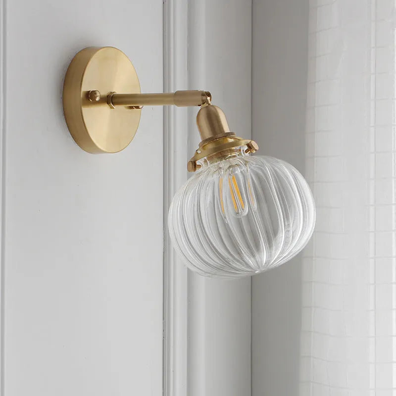 Creative pumpkin-shaped wall lamp with water ripple textured glass shade in blue, mounted on a white wall.