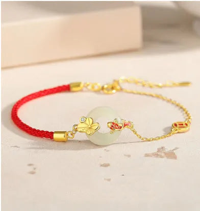 Gold-colour Koi fish charm bracelet in 925 silver with a red rope and peace buckle safety clasp.