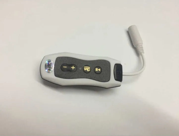 Compact black waterproof MP3 player earphone with USB cable, shown next to a ruler for scale.
