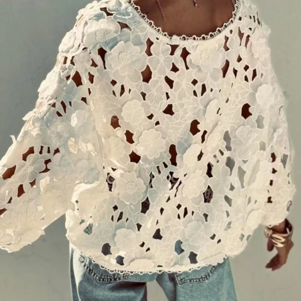 Women's black V-neck lace shirt with white three-dimensional flower decoration and long sleeves.