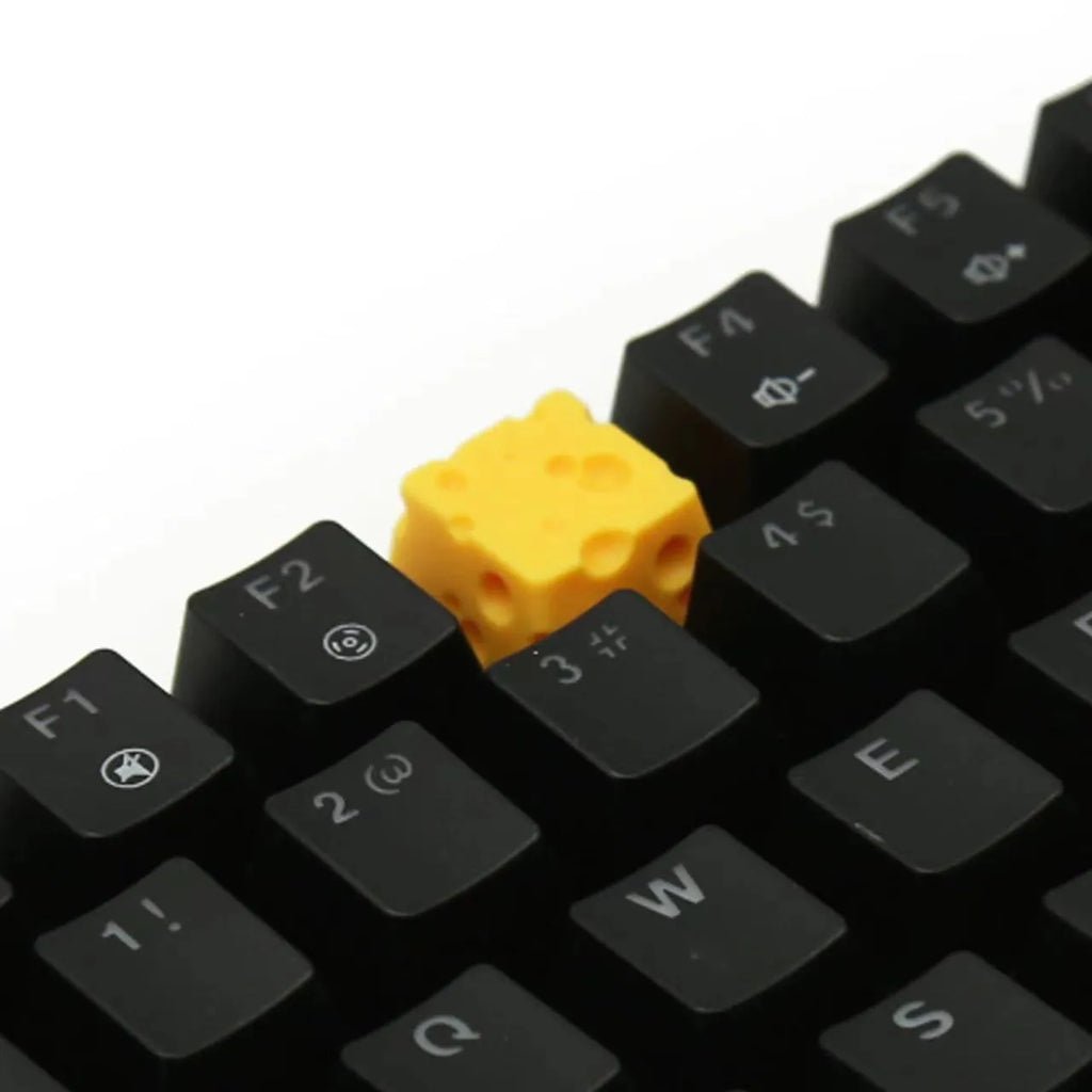 Yellow resin cheese character key cap for mechanical keyboards on a white background.