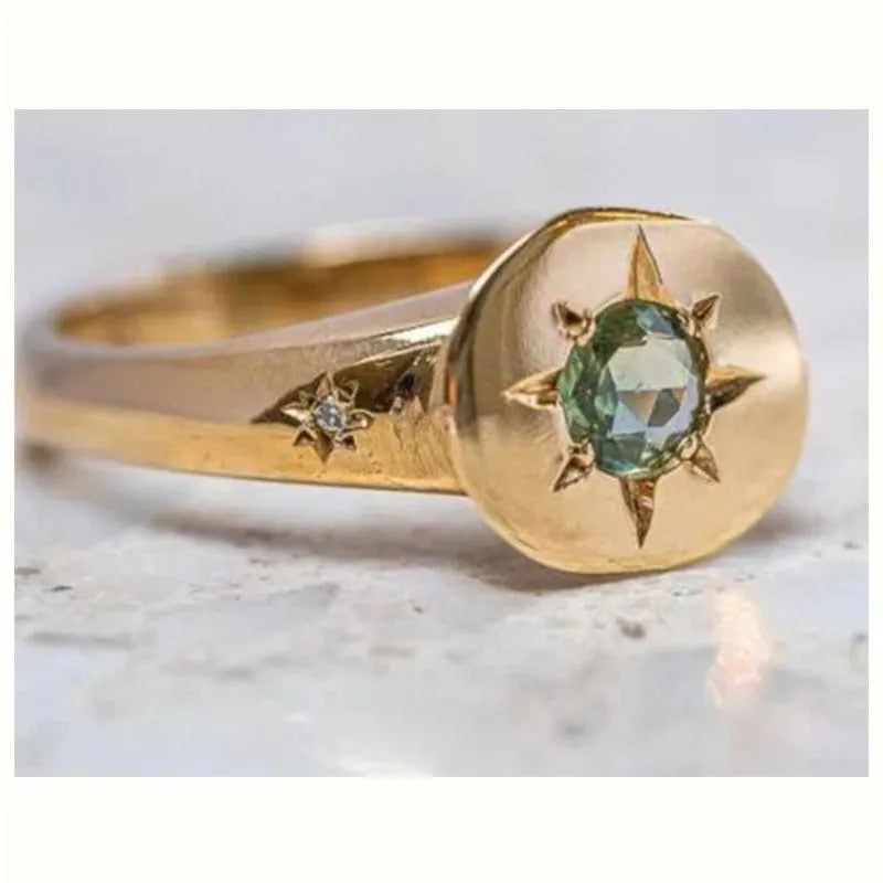 Gold-colour adjustable ring with oval band and central star-shaped zircon stone in a six-prong setting.
