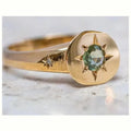 Gold-colour adjustable ring with oval band and central star-shaped zircon stone in a six-prong setting.
