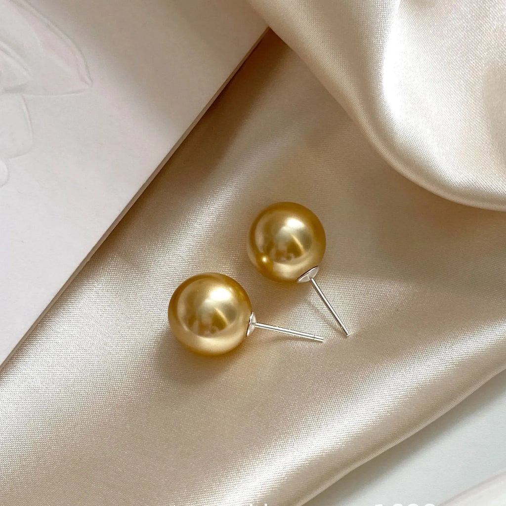 Large pearl stud earrings with a geometric star detail, shown in silver.