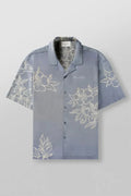 Men's loose-fit short sleeve top with floral print in light colour, laid flat.