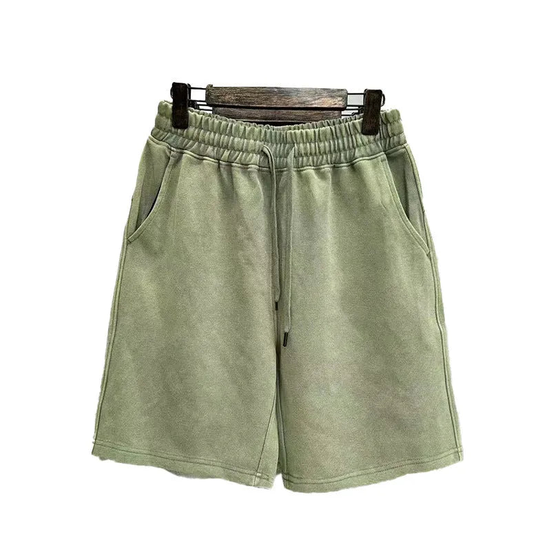Man wearing loose-fit distressed cotton shorts in a solid colour.