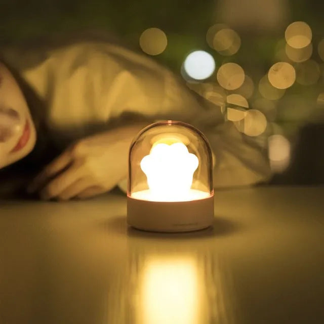 Grey and pink cat paw shaped USB rechargeable night light with rotating dynamic lighting
