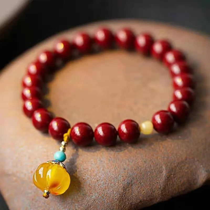 Handmade gold cinnabar wave bracelet showing genuine stone and copper bead construction in national style design