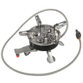 Silver portable folding camping stove with extended copper gas hose, shown on a wooden picnic table.