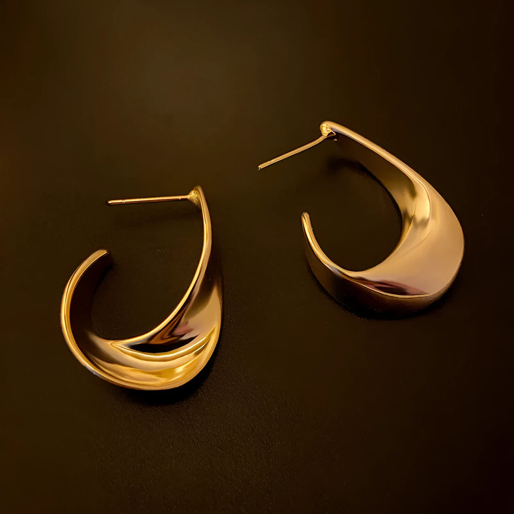 Geometric twist design metal earrings in gold or silver finish with round elements