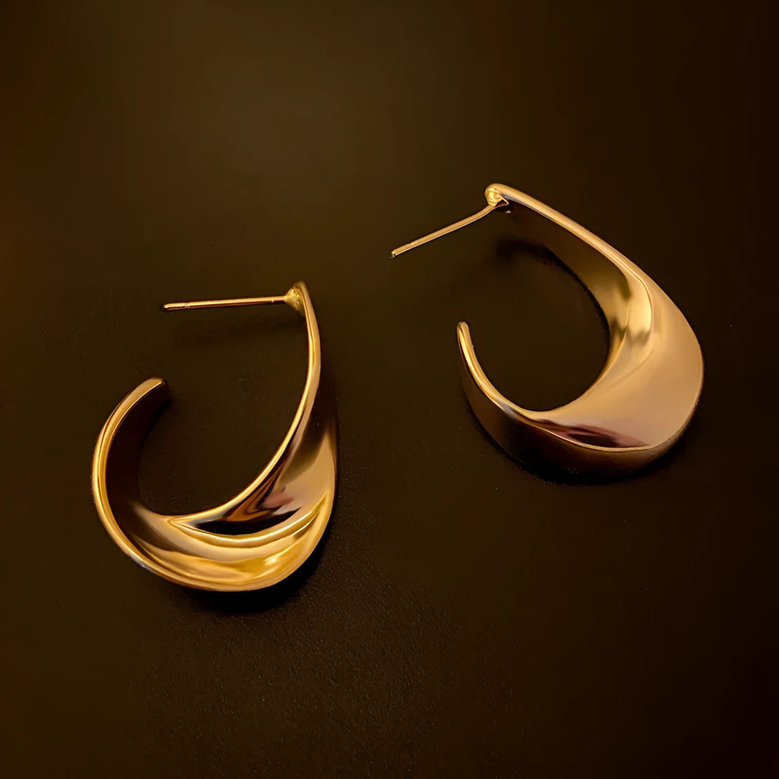 Geometric twist design metal earrings in gold or silver finish with round elements