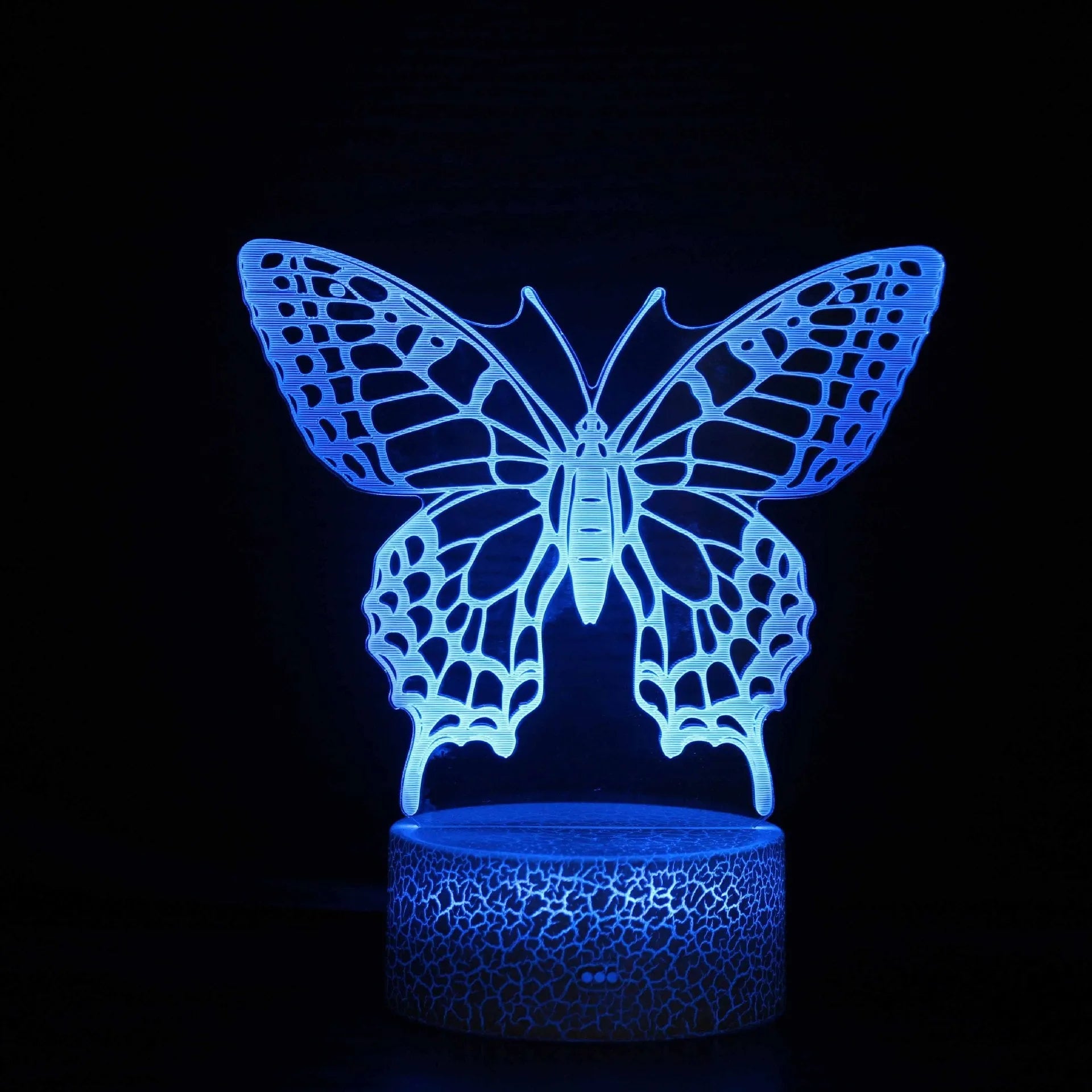 Small blue 3D acrylic USB table lamp with cracked base design lit up on a wooden desk.
