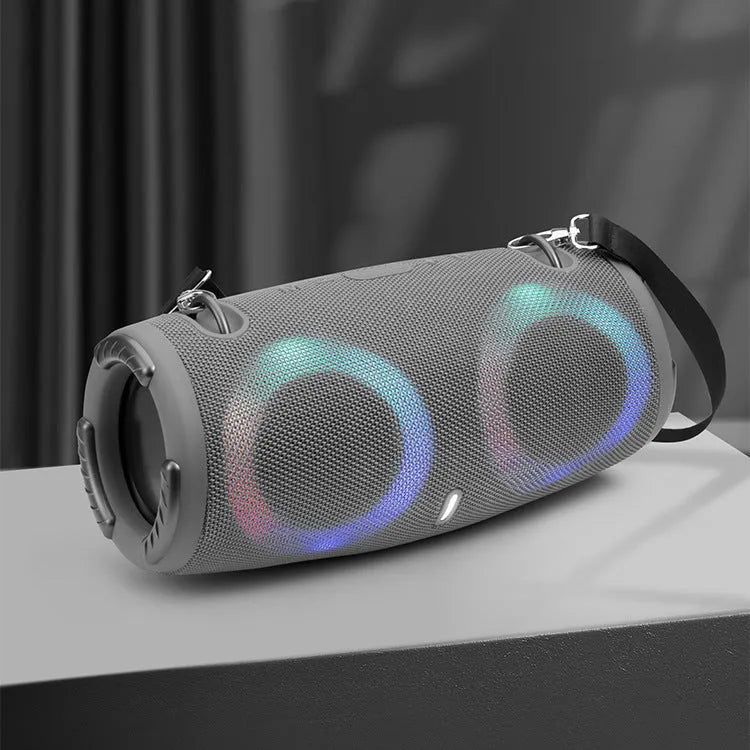 War Drum portable Bluetooth speaker with RGB lights in camouflage finish, showing carry strap and control buttons.