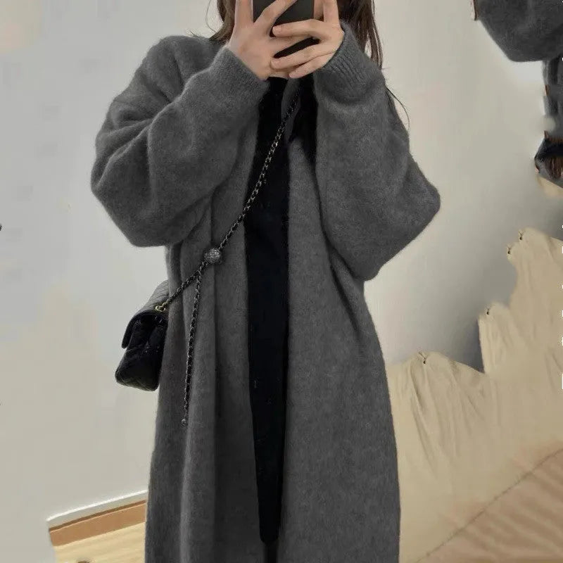 A loose, thick grey knitted women's cardigan with a 3D pattern, shown open as a cardigan.