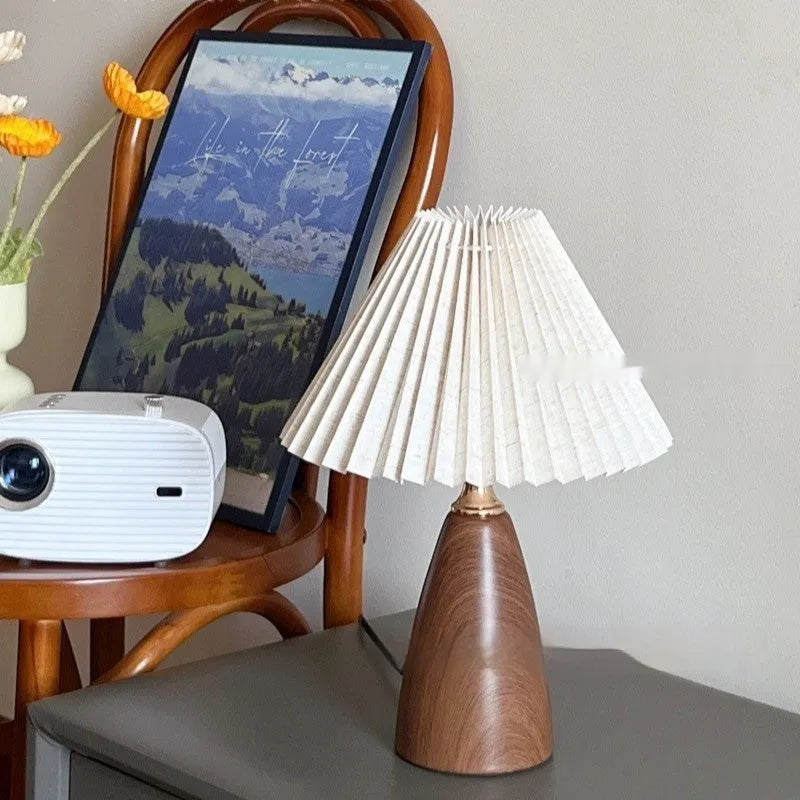 Nordic retro style ceramic table lamp with a tapered floral pleated shade and remote control on a wooden surface.
