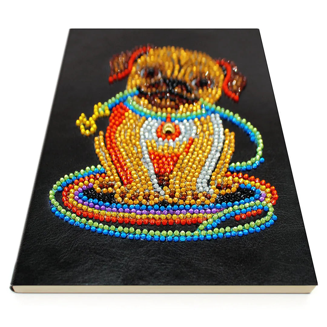 Black A5 hardcover diamond painting notebook with elastic closure, shown closed and open on a crafting table.