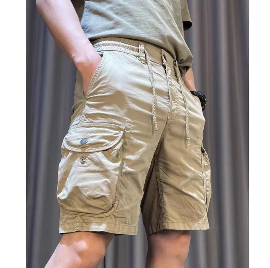 Loose straight-leg casual overalls with multiple cargo pockets in khaki, showing elastic waist and cropped length.