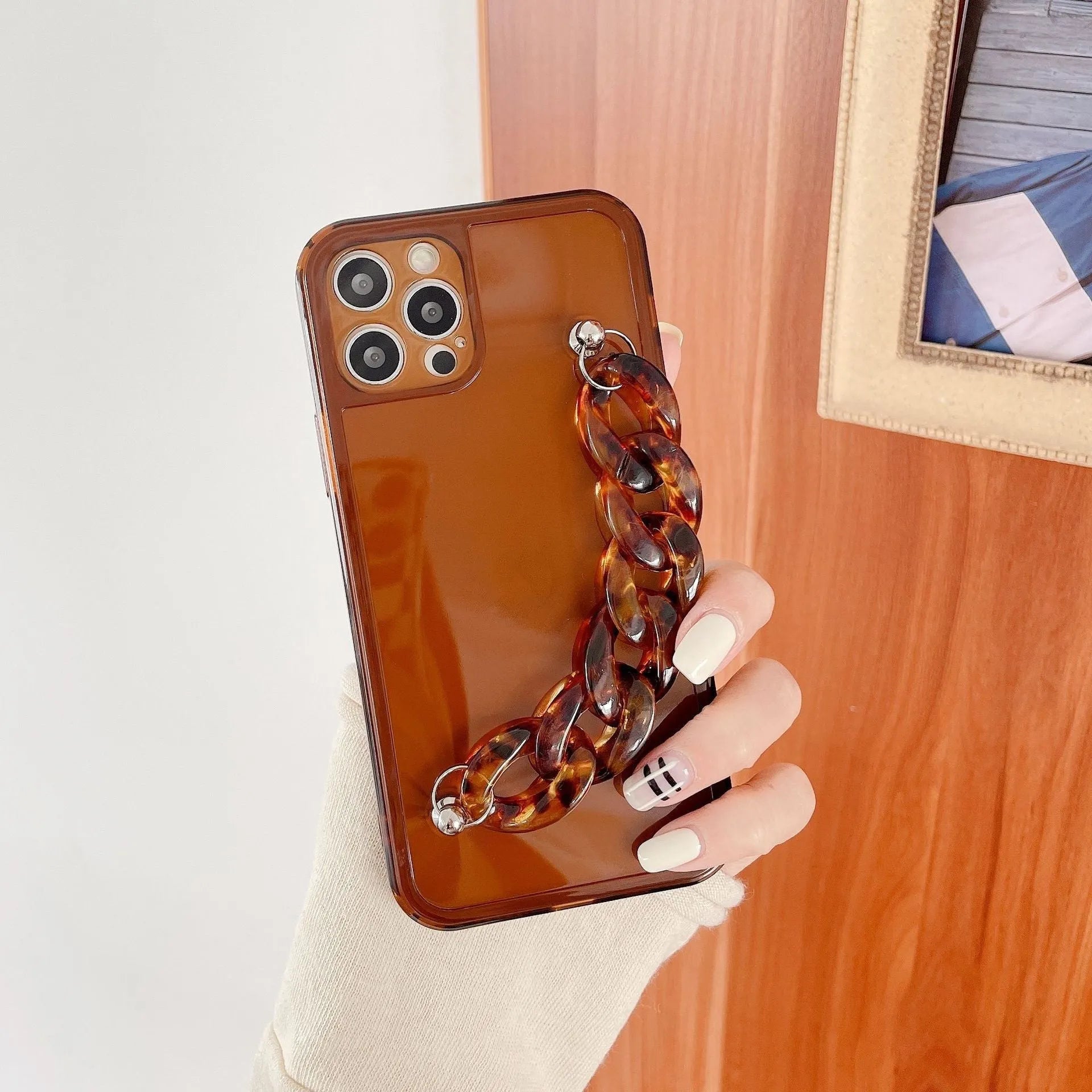 Marbled silicone phone case for iPhone with side lanyard hole in antique white, grey blue, and transparent coffee colours.