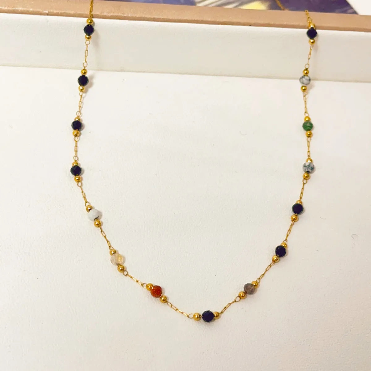 Gold coloured titanium steel necklace with an O-ring chain and a natural stone pendant.