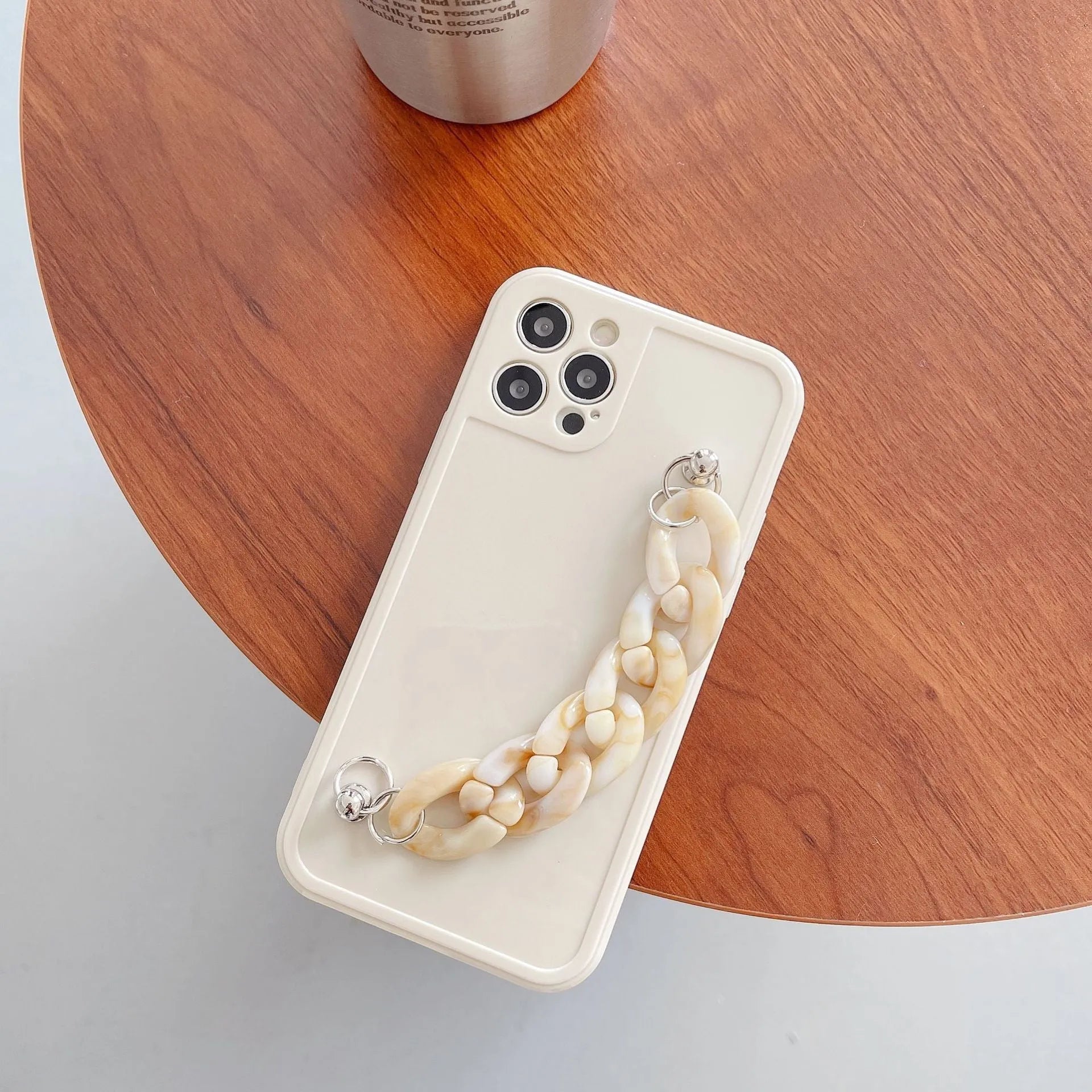 Marbled silicone phone case for iPhone with side lanyard hole in antique white, grey blue, and transparent coffee colours.