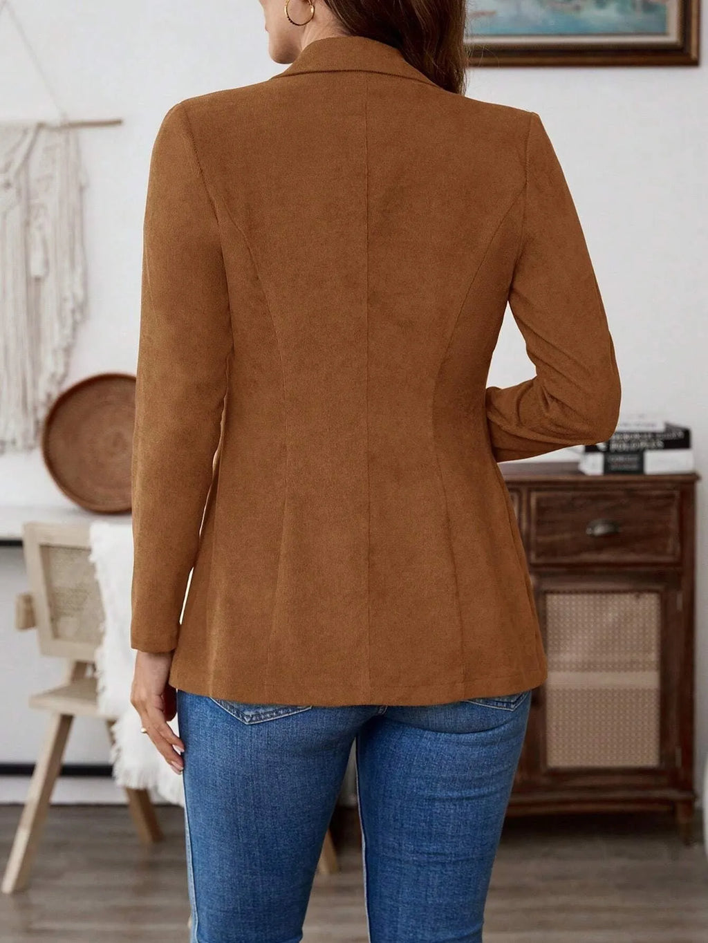 Brown single-breasted suit coat with lapel and long sleeves on a hanger.