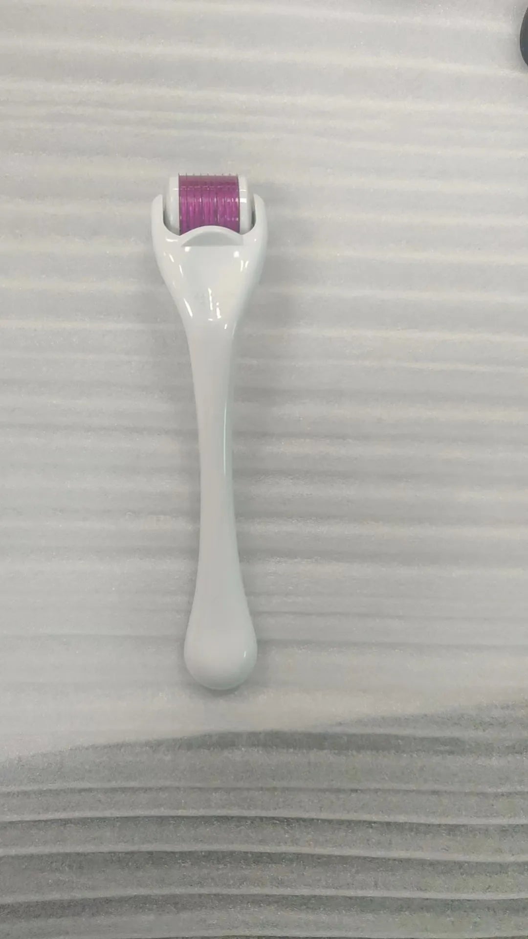 540 micro needle roller tool with black handle and coloured wheel on a white background.