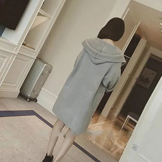 Plus size woman wearing a grey loose-fit cotton coat with lace detailing and long sleeves.