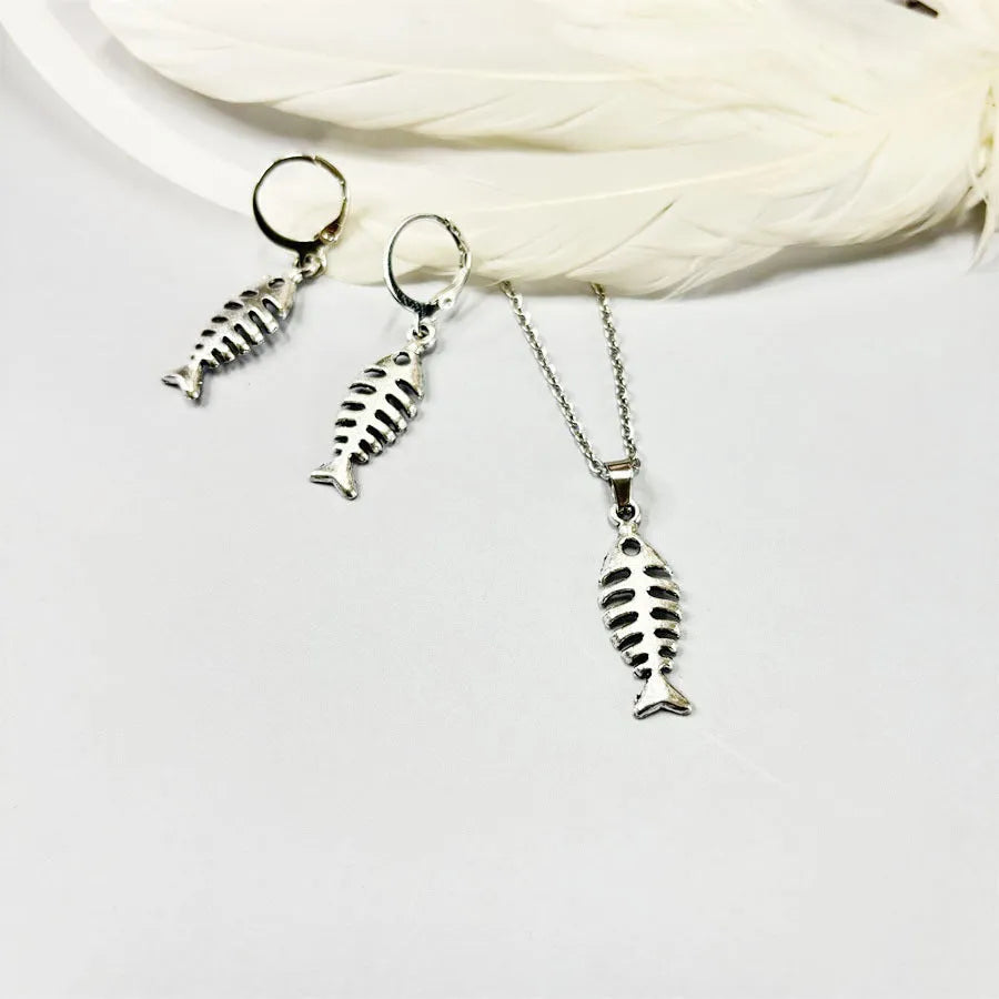 Fishbone pendant necklace and matching earrings set with adjustable chain on grey background