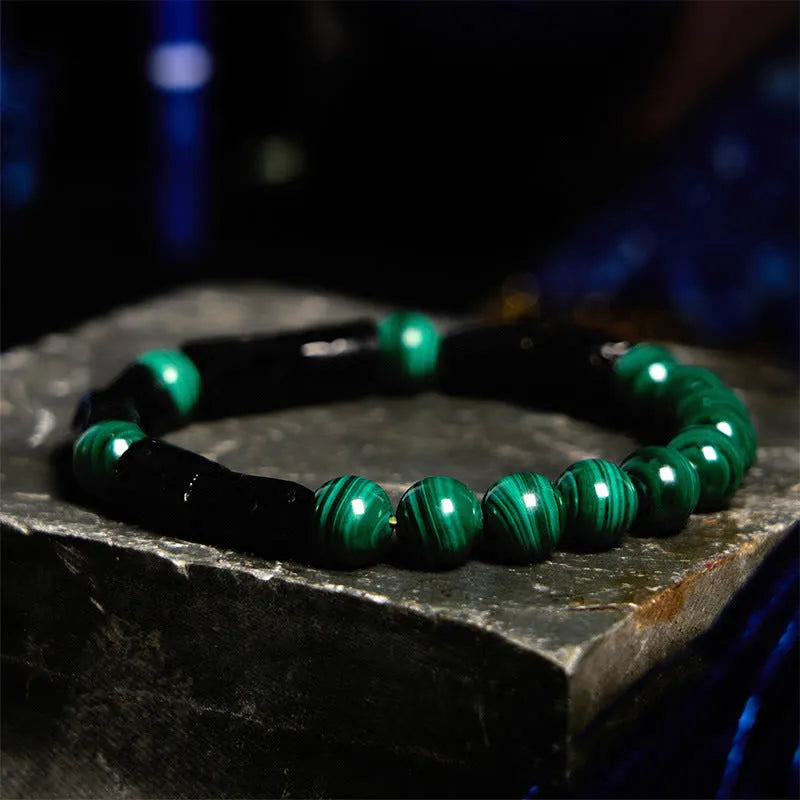 Natural obsidian single ring bracelet with constellation modelling on a wrist.