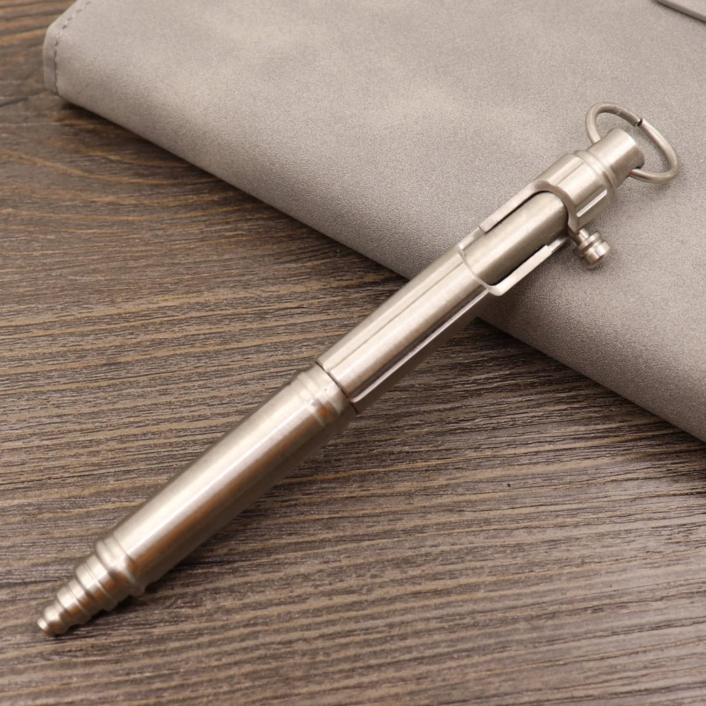Retro brass tactical pen showing press bolt mechanism and cylindrical barrel in natural brass finish.