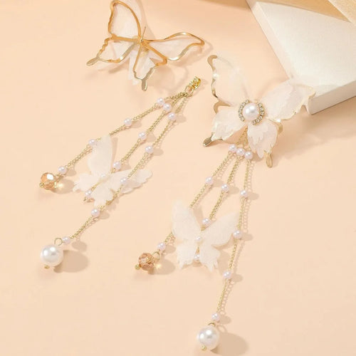 White butterfly shaped earrings with lace metalwork, a dangling tassel, pearl accents, and sparkling rhinestones.