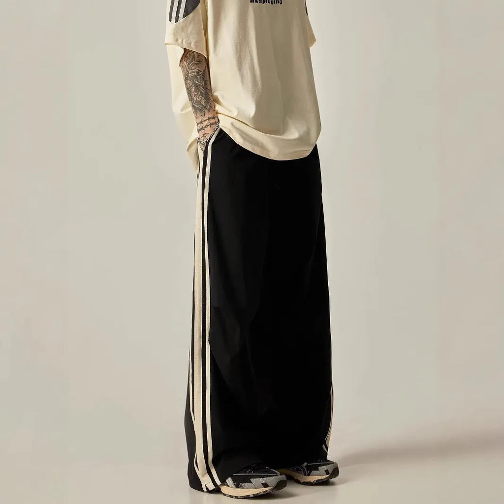 Black wide-leg straight-cut men's climbing trousers with a high waist on a hanger.
