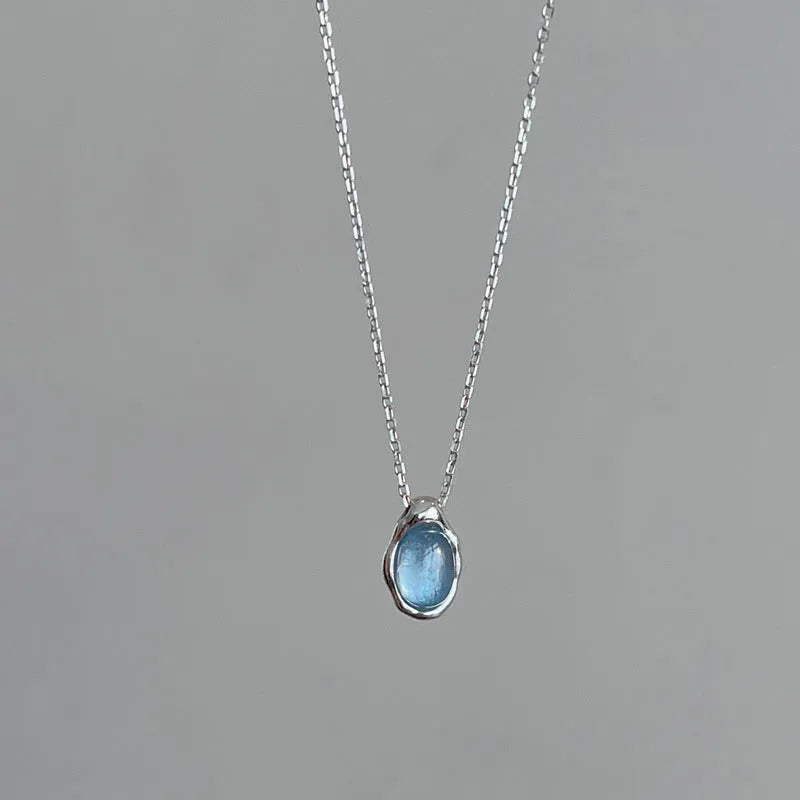 Navy blue geometric water drop pendant necklace on an adjustable cross chain.