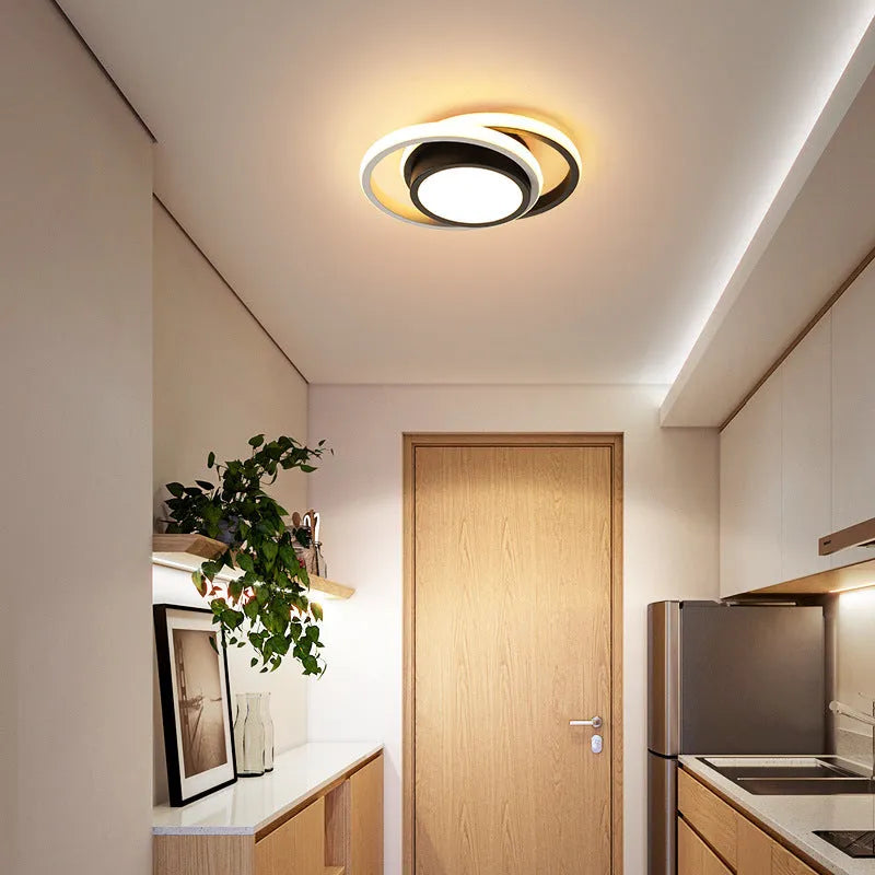 Modern round aluminium ceiling light with integrated LEDs, shown illuminating an entrance hall.