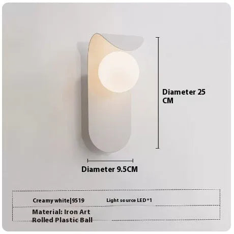 Modern minimalist wall lamp in black finish with LED warm light on a bedroom wall beside bed