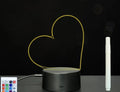 Black 3D acrylic message board night light with remote control and stylus on desk.