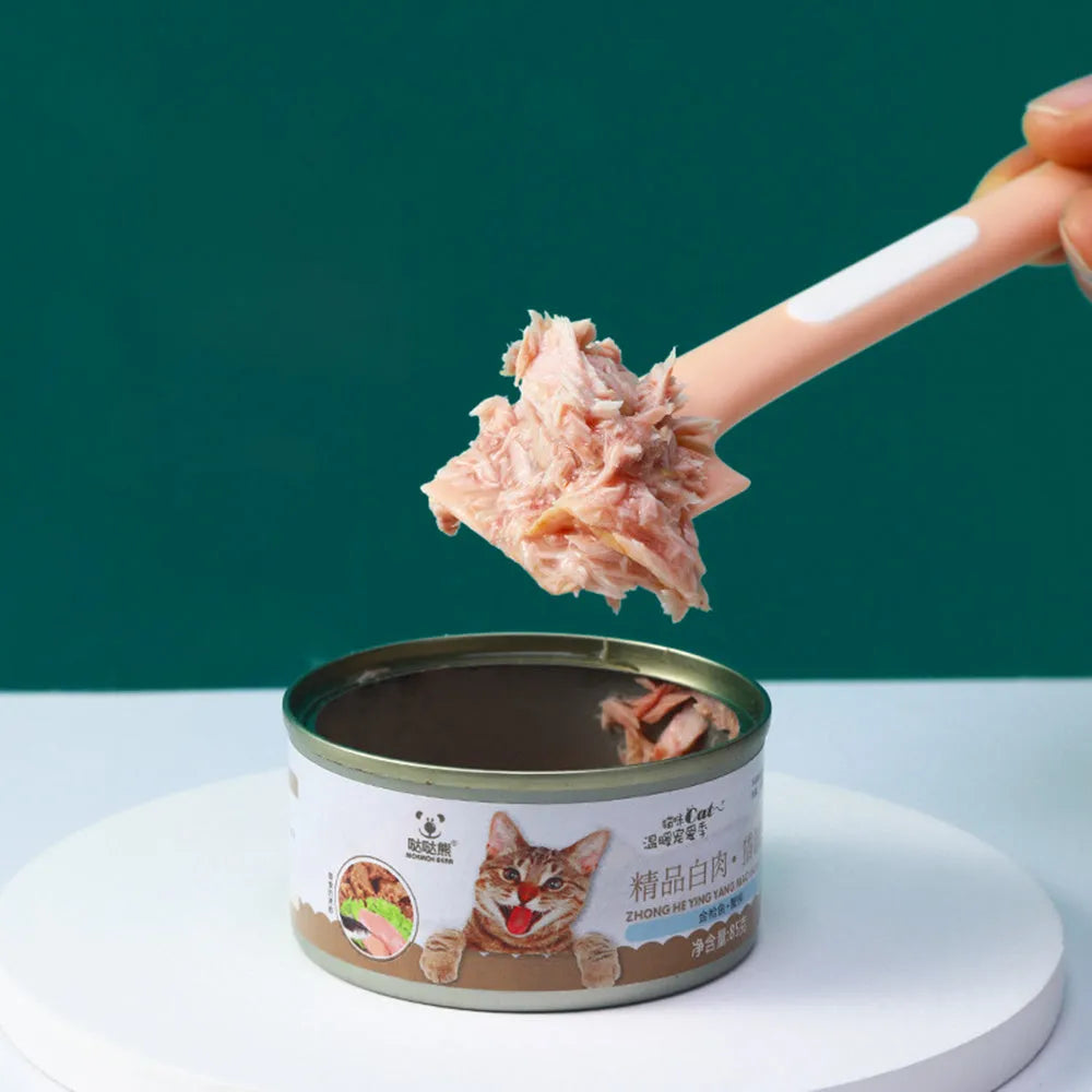 Green long-handled TPR spoon for scooping wet pet food from a tin.