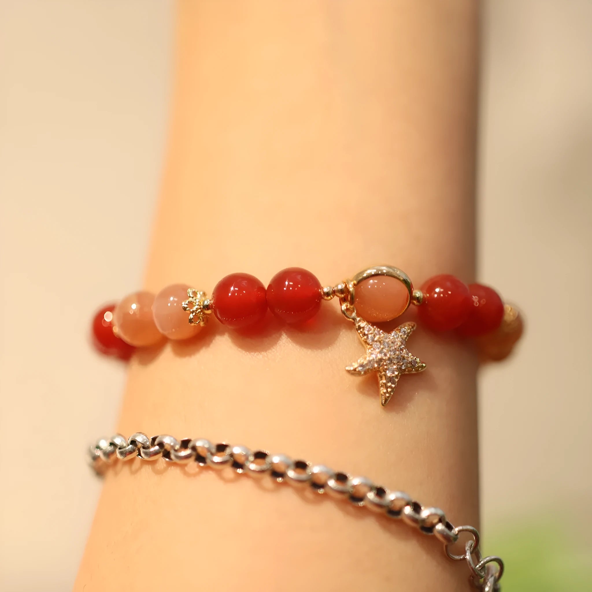 Handmade red agate and orange sunstone bracelet with star and cloud motifs