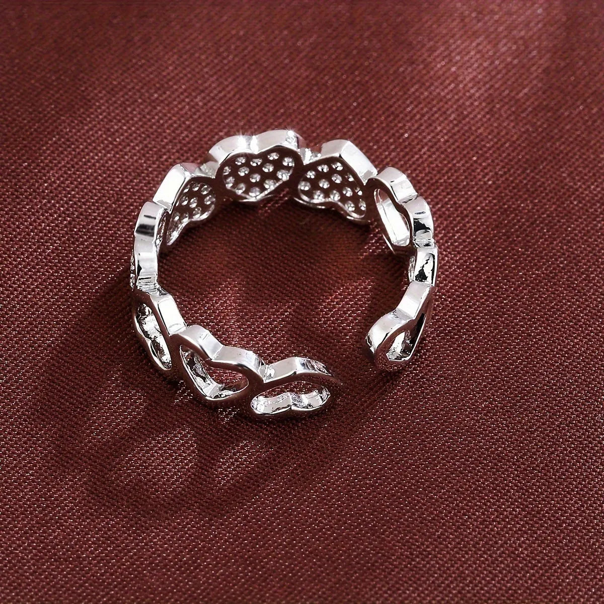 Geometric adjustable heart ring in gold plating, showing diamond-cut facets and open band design.