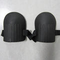 A pair of rectangular EVA foam knee pads in army green colour on a garden soil background.