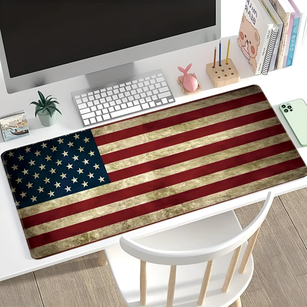 Large printed desk mouse pad with natural rubber non-slip base, shown on a wooden desk.