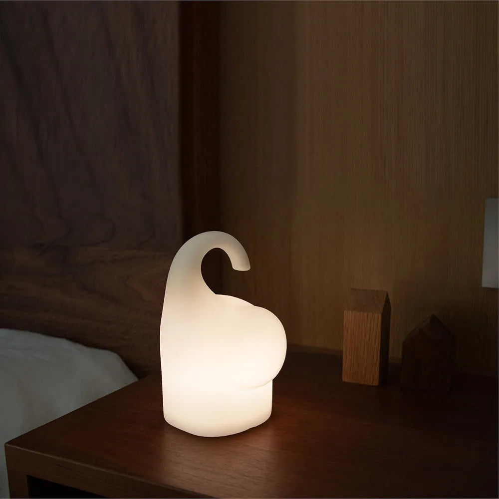 DOMI Elephant shaped silicone night light on a table showing its compact size and soft glow.