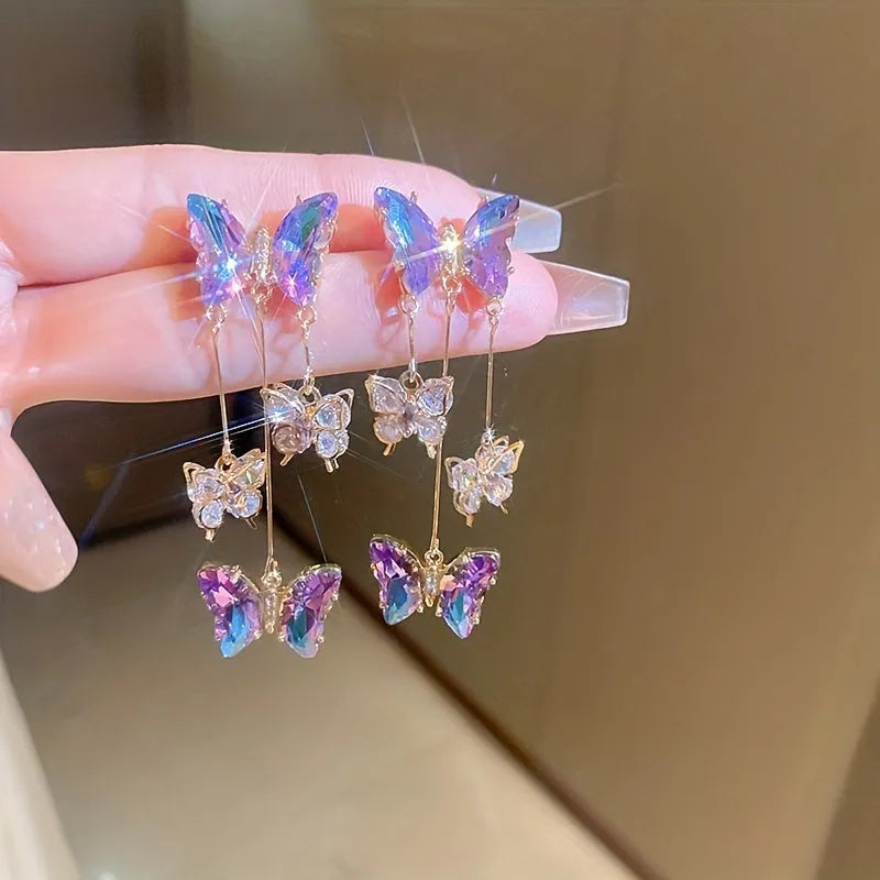 Silver Needle Crystal Flowers Blue Purple Butterfly Tassel Drop Earrings on a white background.