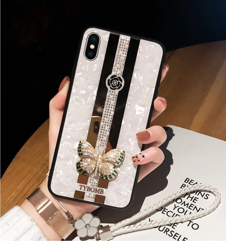Luxury acrylic iPhone case with crystal butterfly design and mirror back, shown in purple.
