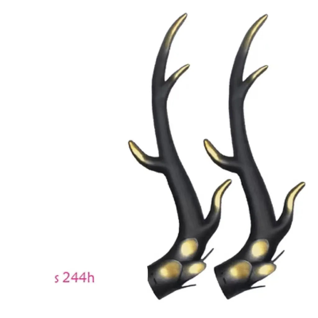 Pair of black resin dragon horn decorations next to a motorcycle helmet, showing scale and detailed texture.